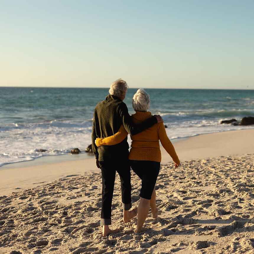 Ægtepar går en tur i strandkanten