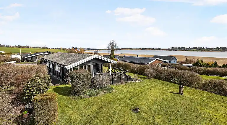 Mysig timmerstuga med utsikt över vattnet