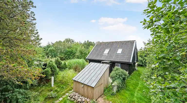 Nydelig strandhus innpakket i grønne omgivelser