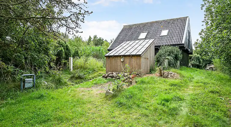 Nydelig strandhus innpakket i grønne omgivelser