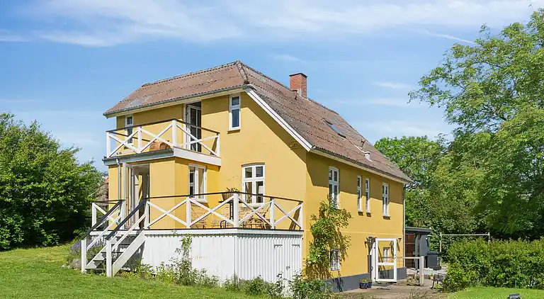 Wunderschöne gelbe Landvilla am Wasser.
