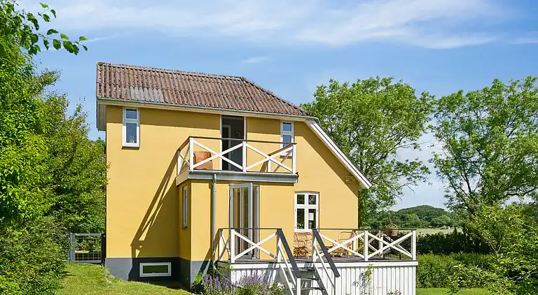 Wunderschöne gelbe Landvilla am Wasser.