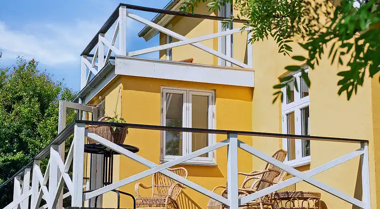 Wunderschöne gelbe Landvilla am Wasser.