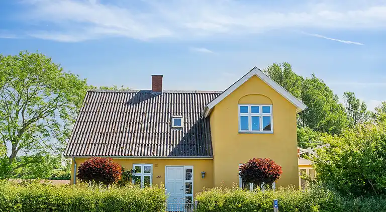 Wunderschöne gelbe Landvilla am Wasser.