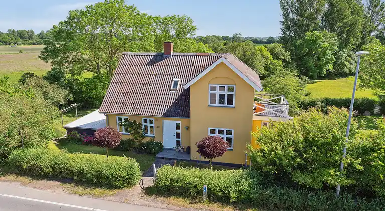 Wunderschöne gelbe Landvilla am Wasser.