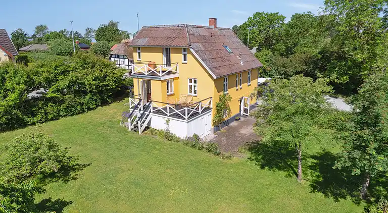 Wunderschöne gelbe Landvilla am Wasser.