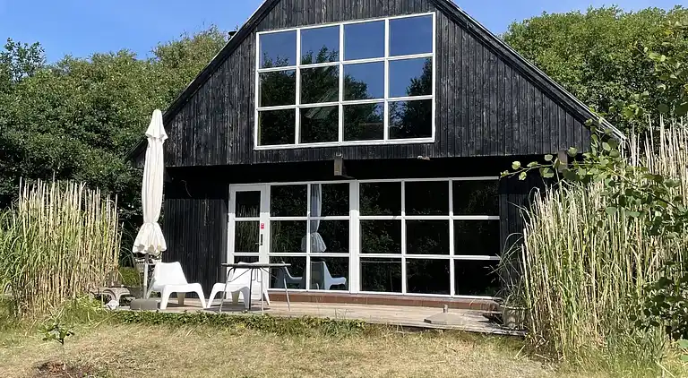 Nydelig strandhus innpakket i grønne omgivelser