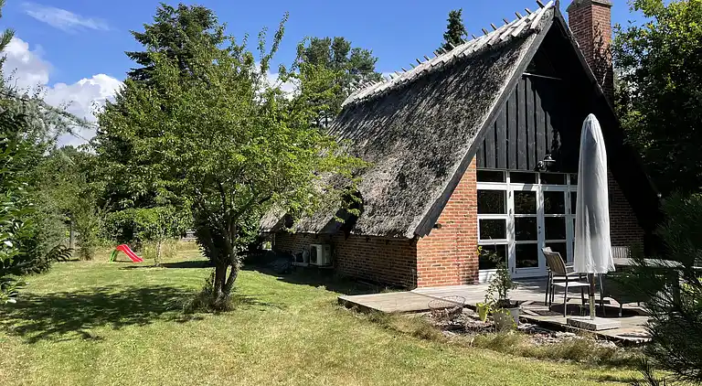 Charmerende sommerhus med stråtag tæt ved vandet