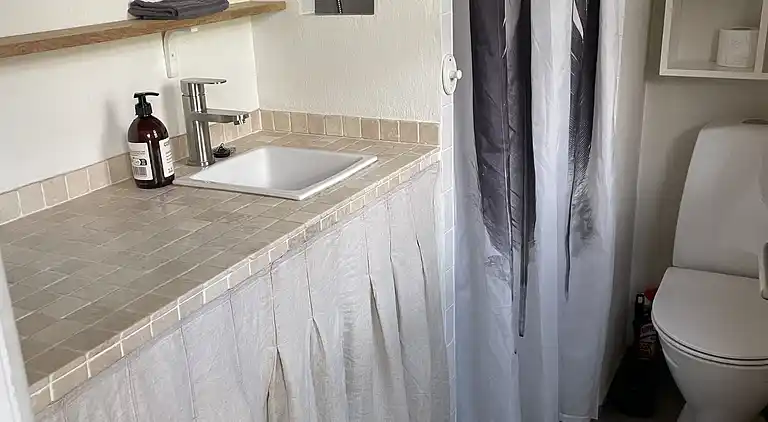 Charmerende sommerhus med stråtag tæt ved vandet