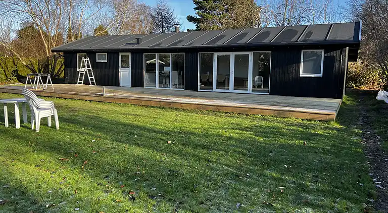 Lyst sommerhus med solrig terrasse og bålsted