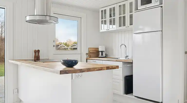 Lyst sommerhus med solrig terrasse og bålsted