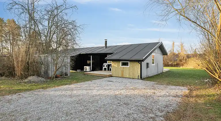 Lyst sommerhus med solrig terrasse og bålsted