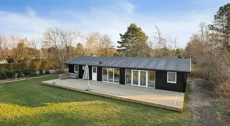 Lyst sommerhus med solrig terrasse og bålsted