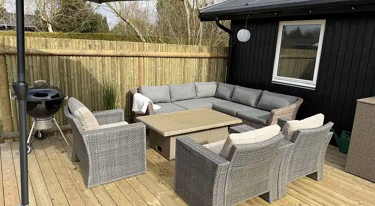 Lyst sommerhus med solrig terrasse og bålsted